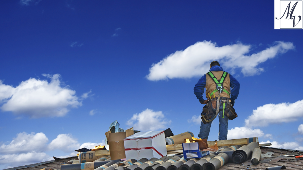 roofer with back toward camera standing on a roof with clouds in background